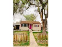 Charming single story home with a pathway leading to a vibrant pink front door and mature trees in the front yard at 1737 Beeler St, Aurora, CO 80010
