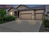 Charming single-Gathering home features a three car garage, stone accents, and well-manicured landscaping at 5670 Pinto Valley St, Parker, CO 80134