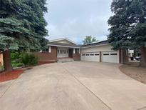Charming brick home with large driveway and a three-car garage at 7079 Estes Dr, Arvada, CO 80004