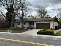 Charming single-story home features a well-maintained front yard and a two-car garage at 6085 Simms St, Arvada, CO 80004