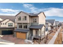 Charming two-story home featuring solar panels and a well-maintained front yard with porch and two car garage at 5480 Danube St, Denver, CO 80249