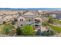 Well-manicured two-story home boasts a beautiful exterior with stone accents, a covered balcony, and a spacious patio at 10698 Mountaingate Ct, Littleton, CO 80126