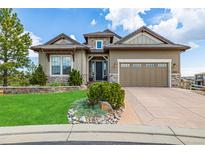 Charming home with a well-manicured lawn and stone accents, complemented by a two-car garage at 10698 Mountaingate Ct, Littleton, CO 80126