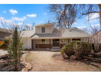 Charming two-story home with a welcoming front entrance and mature trees on a sunny day at 10053 Lewis St, Broomfield, CO 80021