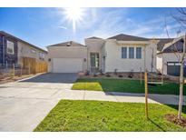 Charming single-Gathering home with white brick and siding, a well-manicured lawn, and a two-car garage at 17054 Hop Clover Ave, Parker, CO 80134