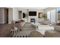 Modern living room with stylish furniture, a fireplace, large windows, and contemporary artwork creating an inviting space at 17054 Hop Clover Ave, Parker, CO 80134