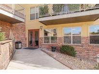 Exterior entrance to building shows a brick facade, walkway, and updated windows and balconies at 9079 E Panorama Cir # 520, Englewood, CO 80112