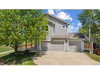 Charming two-story home with a three-car garage and mature landscaping on a sunny day at 10570 Echo Ct, Firestone, CO 80504