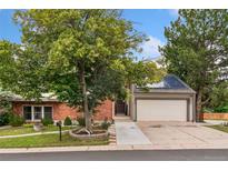 Charming home featuring brick and siding exterior, mature trees, and a two-car garage at 3390 S Ensenada Way, Aurora, CO 80013