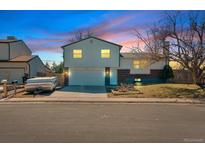 Charming two-story home with a spacious two-car garage and inviting curb appeal at dusk at 9120 W Bellwood Pl, Littleton, CO 80123