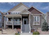 Charming two-story home with mixed stone and siding, covered porch, and well-maintained landscaping at 4483 Fell Mist Way, Castle Rock, CO 80109