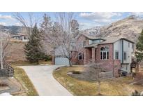 A stunning two-story home boasts brick and siding accents, complemented by an extended driveway and meticulously landscaped grounds at 1923 Parfet Estates Dr, Golden, CO 80401
