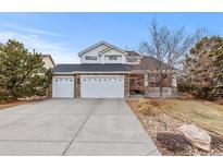 Charming two-story home featuring stone accents, a spacious driveway, and a three-car garage at 4823 Craftsman Dr, Parker, CO 80134