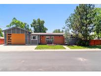 Charming single-story home with a modern design, wood accents, gray siding, and a well-manicured lawn at 5480 W Iowa Ave, Lakewood, CO 80232