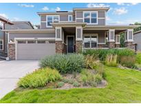 Charming two-story home with a well-manicured lawn, covered porch, stone accents, and a spacious two-car garage at 1902 Pioneer Cir, Lafayette, CO 80026