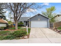 Charming gray home featuring mature landscaping, a two-car garage, and welcoming curb appeal at 8896 W Teton Cir, Littleton, CO 80128