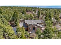 Stunning exterior elevation of a home nestled among the trees with a welcoming entrance and a terraced front yard at 19595 E Top O The Moor Dr, Monument, CO 80132