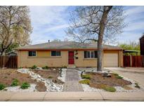 Charming ranch-style home with a red door, landscaped front yard, and attached one car garage at 6020 Quail St, Arvada, CO 80004