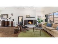 Cozy living room featuring a fireplace, wood floors, and neutral tones at 7250 Eastmoor Dr # 203, Denver, CO 80237
