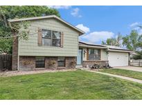 Charming split-level home with a well-maintained lawn and flower boxes adding curb appeal at 309 S 30Th Ave, Brighton, CO 80601