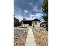 Charming single-story home featuring a welcoming walkway and landscaped yard with decorative rocks at 1455 Hudson St, Denver, CO 80220