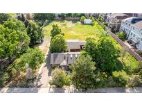Aerial view of home with a well-kept roof, large lawn area, and surrounded by mature trees in a quiet neighborhood at 1245 S Willow St, Denver, CO 80247