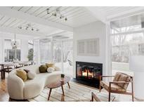 Inviting living room with a fireplace, large windows, and access to the outdoor area for relaxation at 1459 S Filbert Way, Denver, CO 80222