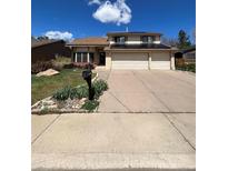 Charming two-story home featuring a three-car garage, well-manicured lawn, and installed solar panels at 15983 E Loyola Dr, Aurora, CO 80013