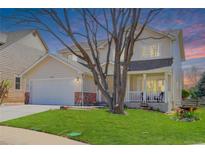 Charming two-story home with a well-manicured lawn, covered porch, and a two-car garage, providing an inviting curb appeal at 19058 E Hickock Dr, Parker, CO 80134