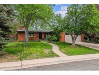 Charming brick home featuring a lush lawn, mature trees, and a welcoming walkway to the front door at 2041 W Briarwood Ave, Littleton, CO 80120