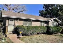 Charming single-story home featuring tidy landscaping, complemented by mature trees and a secure metal security door at 200 Perry St, Denver, CO 80219