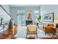 Bright living room features hardwood floors, fireplace, and sliding door to the outdoors at 1777 S Union Blvd, Lakewood, CO 80228