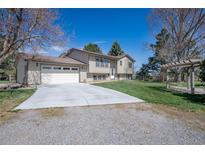 Inviting home with a large driveway, attached garage, and well-maintained front lawn at 2781 Savage Rd, Elizabeth, CO 80107