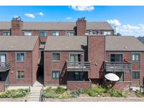 A multi-Gathering residential building with a balcony, landscaping, and a charming red wood facade at 311 W Lehow Ave # 3, Englewood, CO 80110