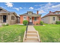 Charming brick home with a well-manicured lawn and inviting walkway to the front door at 2204 S Acoma St, Denver, CO 80223
