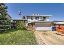 Charming two-story home with brick accents, an attached two-car garage and well-manicured lawn at 4845 S Taft St, Morrison, CO 80465