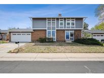 Two-story home with brick and gray siding, featuring a well-manicured front yard and an attached two car garage at 3660 S Ouray Cir, Aurora, CO 80013