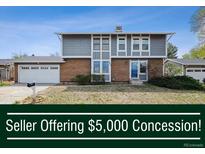 Charming two-story home with a brick facade, gray siding, and an attached two-car garage at 3660 S Ouray Cir, Aurora, CO 80013