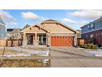 One-story home with stone and wood siding, attached garage, and landscaped yard at 464 N Jamestown Way, Aurora, CO 80018