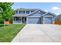 Charming two-story home featuring a covered front porch and a three car attached garage at 17395 E Dewberry Dr, Parker, CO 80134