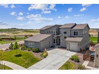 Beautiful home showcasing stone accents, a three-car garage, and manicured landscaping at 8299 S Kellerman, Aurora, CO 80016