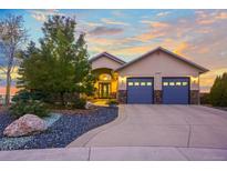 Charming home with a blue two-car garage, beautiful landscaping, and an inviting entrance at 1743 Homestead Dr, Fort Lupton, CO 80621