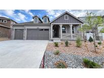 Charming gray two-story home featuring a two-car garage and welcoming front porch at 3991 Descent St, Castle Rock, CO 80108