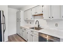 Bright kitchen features white cabinetry, stainless steel appliances, and updated countertops at 3141 S Tamarac Dr # 206E, Denver, CO 80231