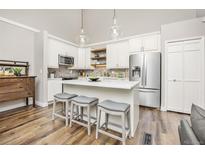Bright kitchen with quartz countertops, stainless steel appliances, kitchen island and pendant lighting at 6513 Pinewood Dr, Parker, CO 80134