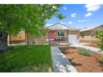 Charming brick home with a well-manicured lawn, a pink front door, and a cozy front porch at 3241 Sheridan Blvd, Wheat Ridge, CO 80212