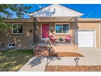 Charming brick home with a cozy front porch and vibrant pink front door at 3241 Sheridan Blvd, Wheat Ridge, CO 80212