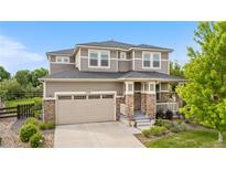 Beautiful two-story home with manicured lawn, stone accents, and a two-car garage on a sunny day at 1920 Pioneer Cir, Lafayette, CO 80026