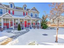 Two-story townhome with red front door and snow-covered yard at 14653 E Crestridge Dr, Centennial, CO 80015