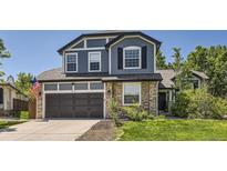 Beautiful two-story home featuring stone accents, a two-car garage, and manicured landscaping at 9545 Grand Cypress Cv, Lone Tree, CO 80124
